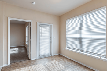 a living room with two large windows and a door to the patio